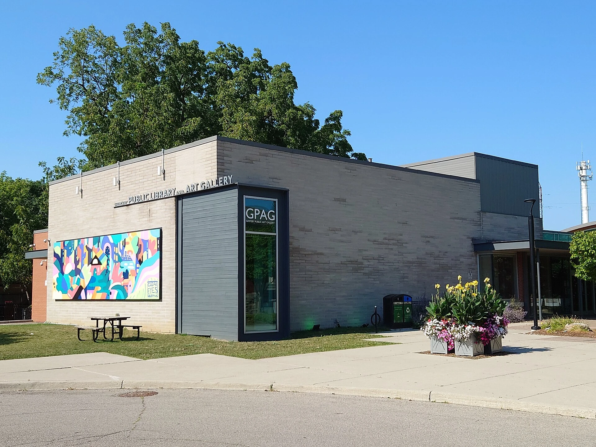 Framed paintings of nature and animals displayed on the wall of a small community art gallery.