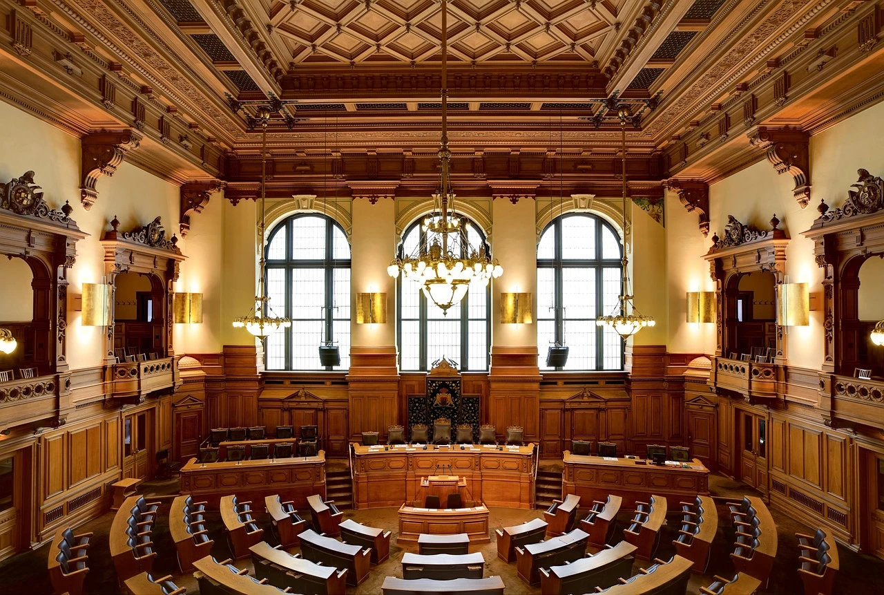 A modern sculpture with two circular forms and leaf shapes inside a renovated council chamber.