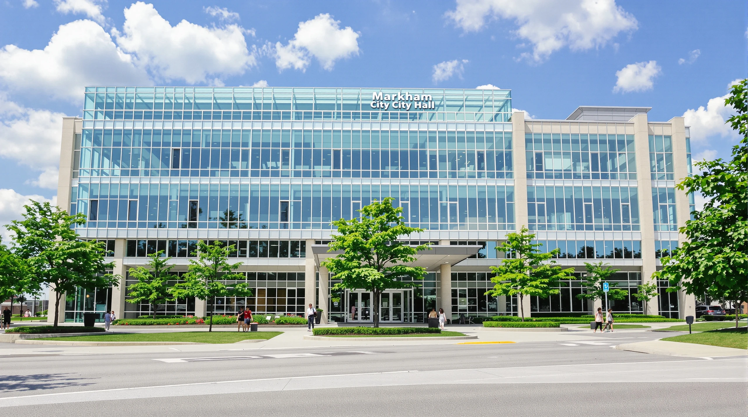 A modern civic building with glass entrance and green summer landscaping in Markham.