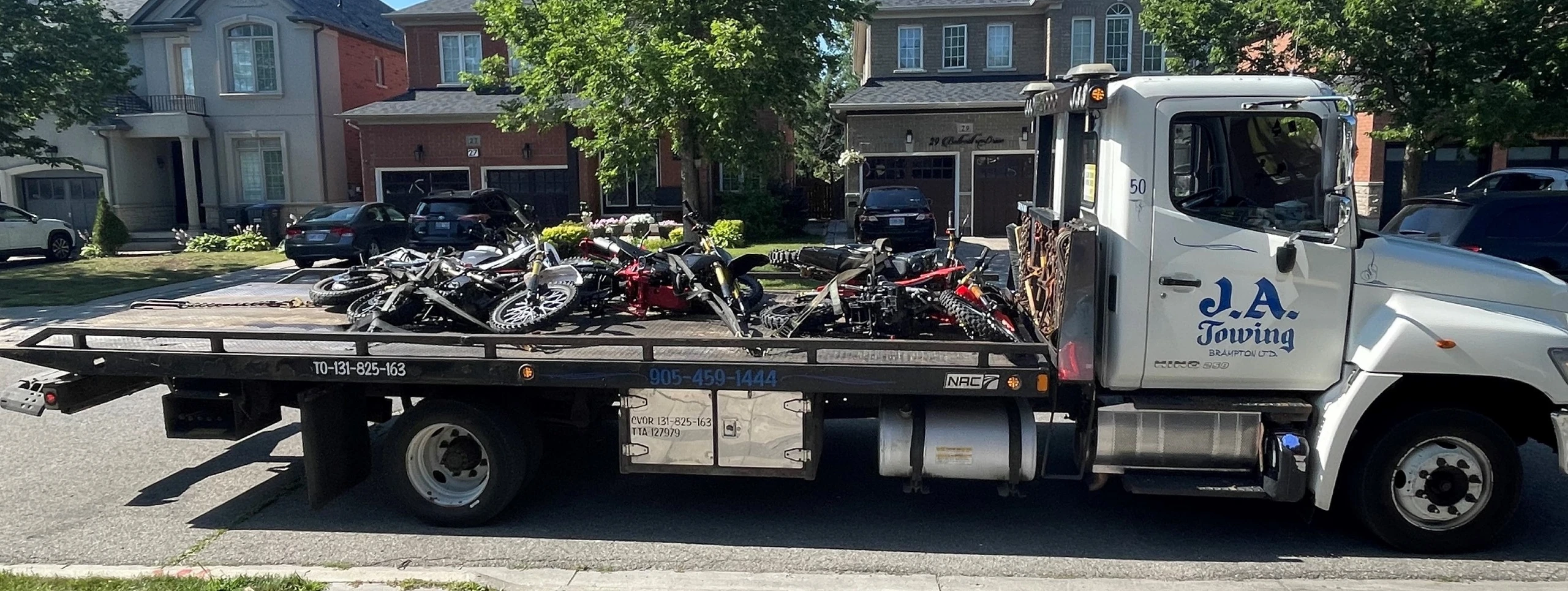A police cruiser parked at a station with a dirt bike in the foreground.
