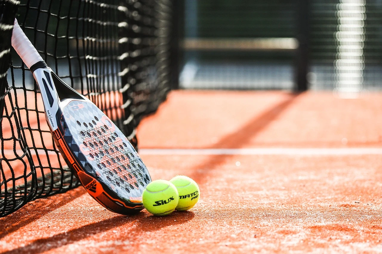 Empty outdoor pickleball and tennis courts with fresh blue and green surfaces, surrounded by trees and a fence at a Toronto park in summer.