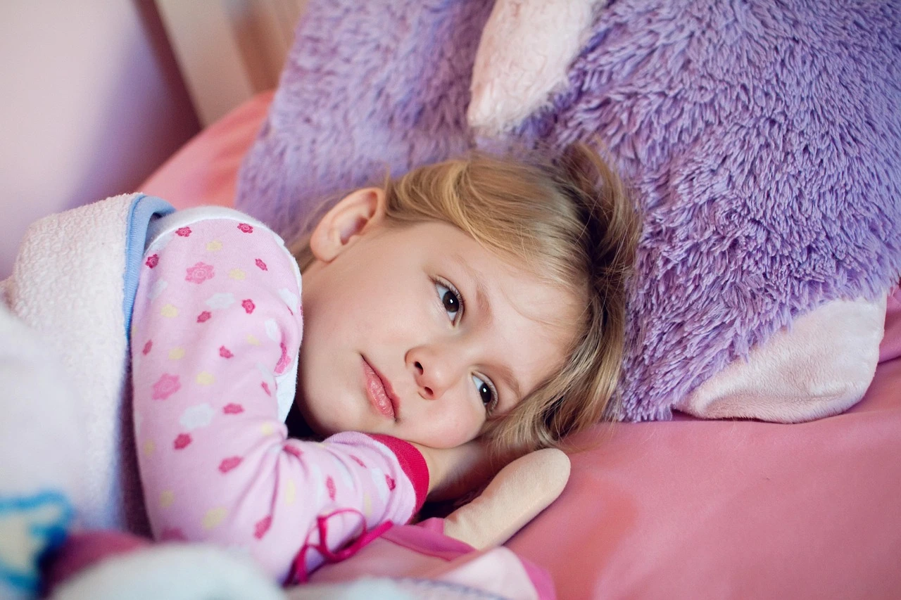 A cozy child's bedroom with autumn-themed bedding and morning sunlight filtering through the window.