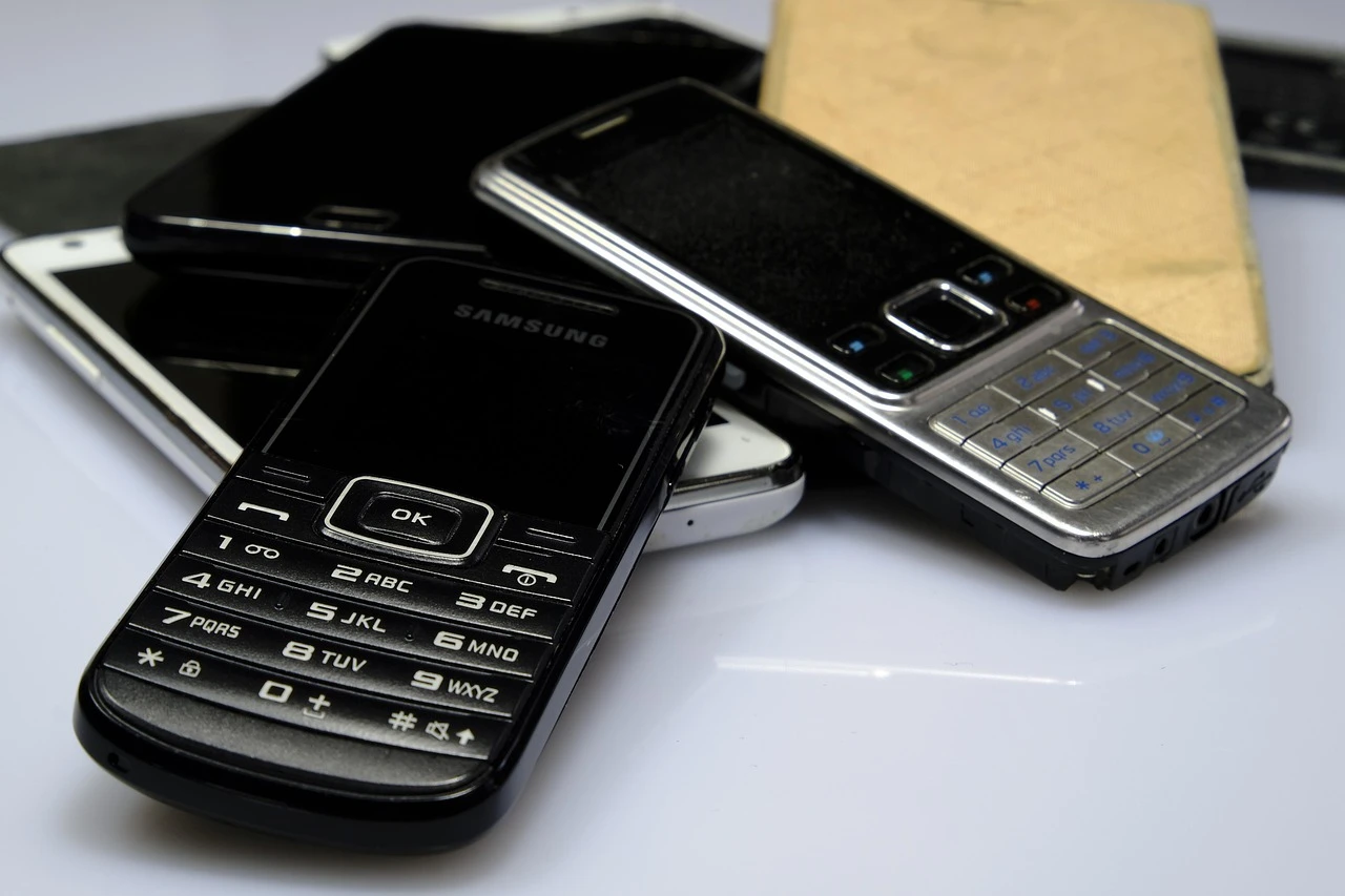 A pile of various mobile phones stacked on a surface.