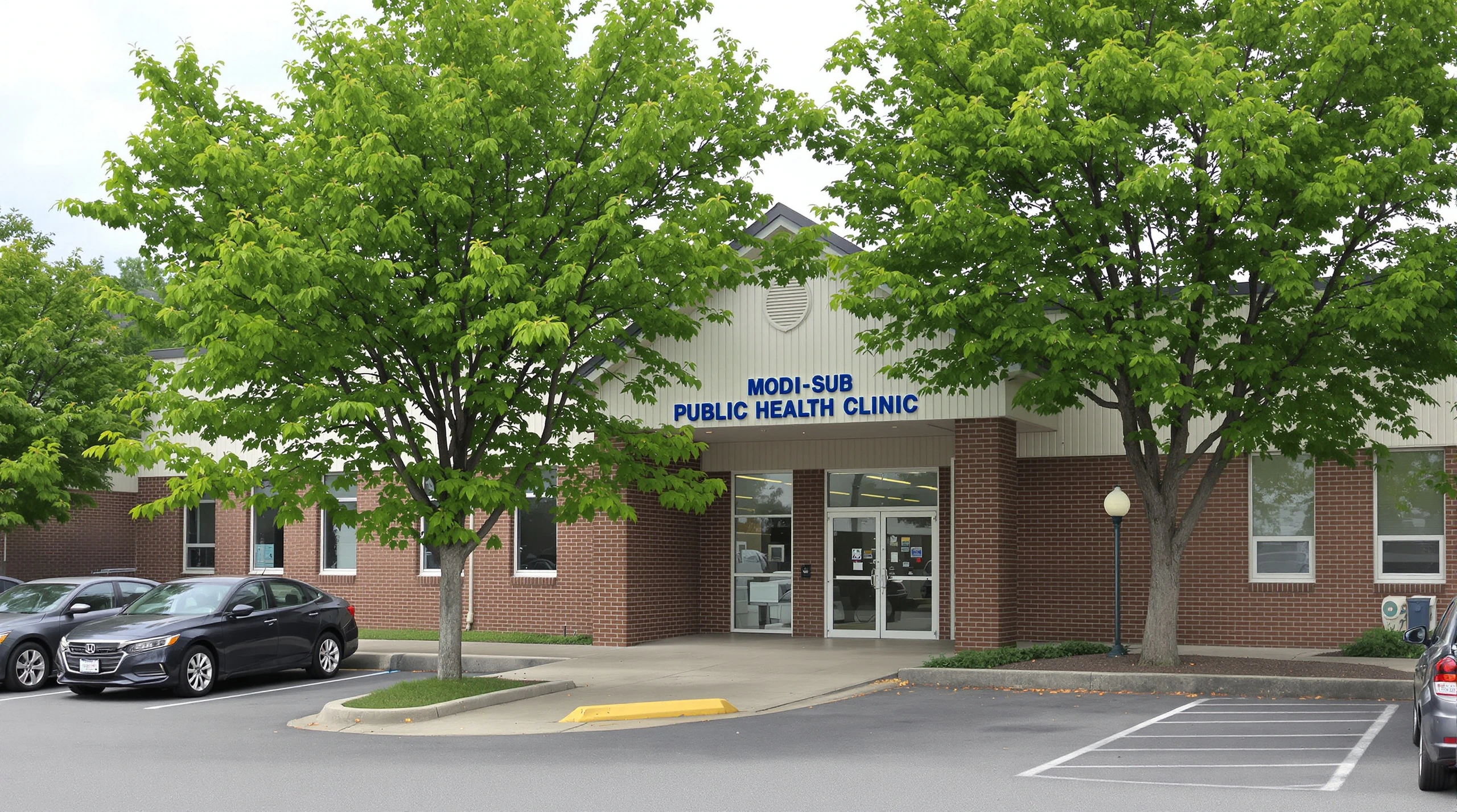 The exterior of a public health clinic building in Ottawa on a summer day, with green trees and a parking lot.
