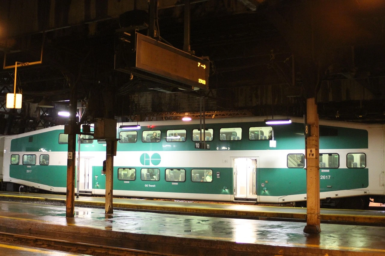 A GO commuter train at a station platform in autumn along the Lakeshore West corridor.