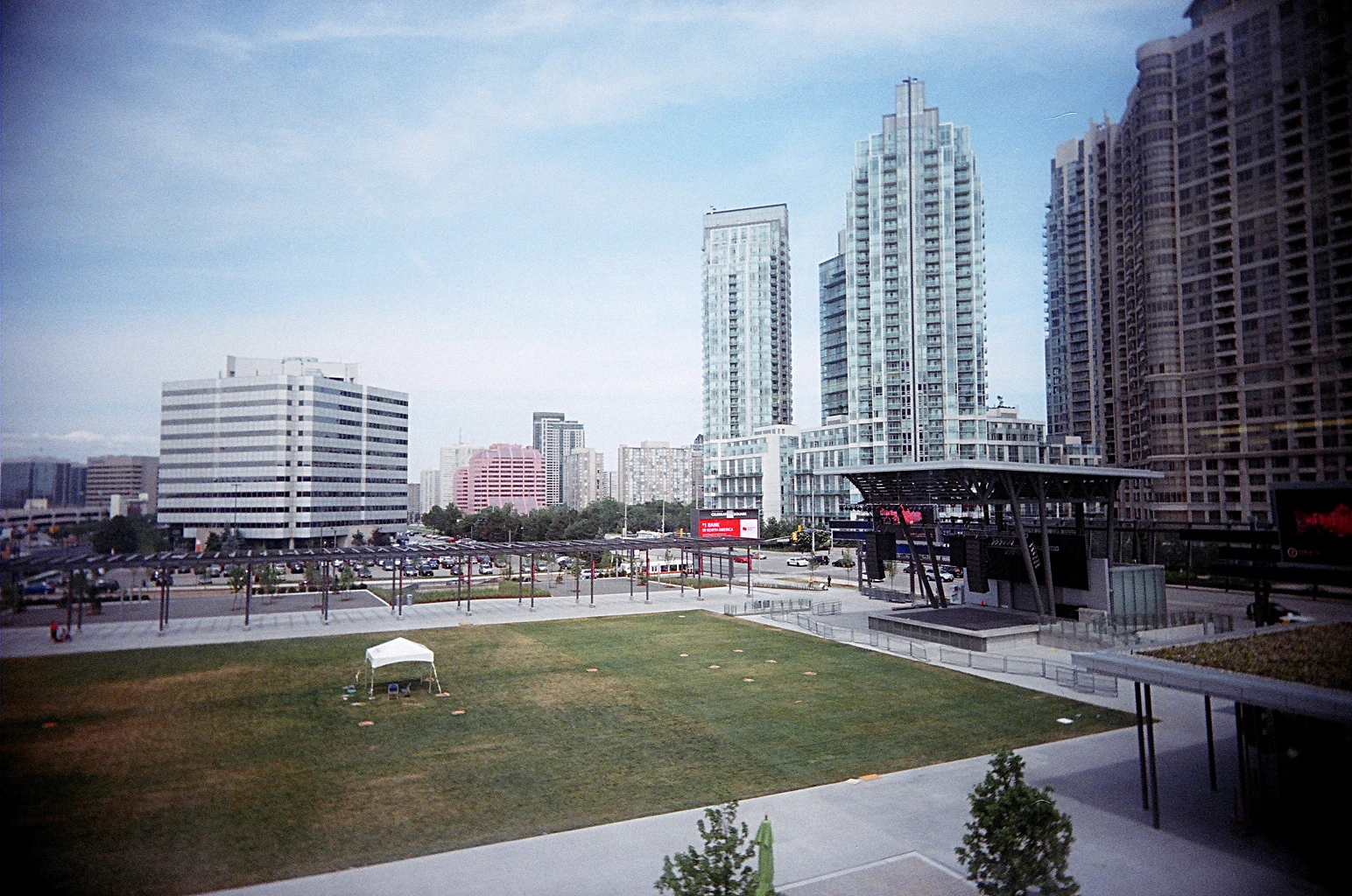 Crowd gathered at an evening outdoor festival with food vendors and a stage in a Canadian civic square.