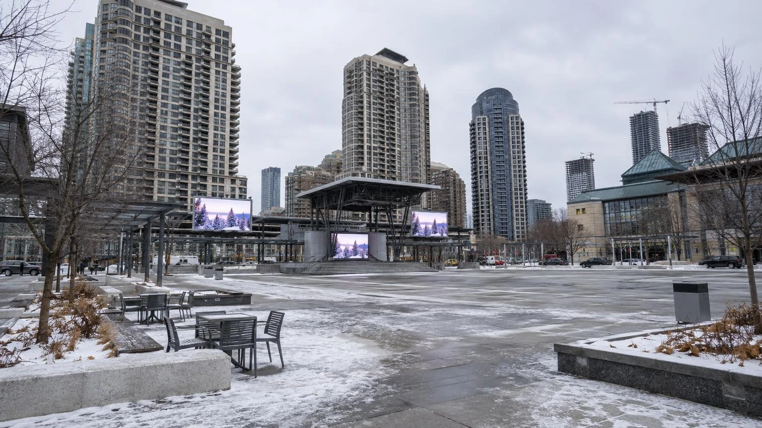 An empty urban plaza in Mississauga with outdoor seating and modern landscaping under a grey winter sky.