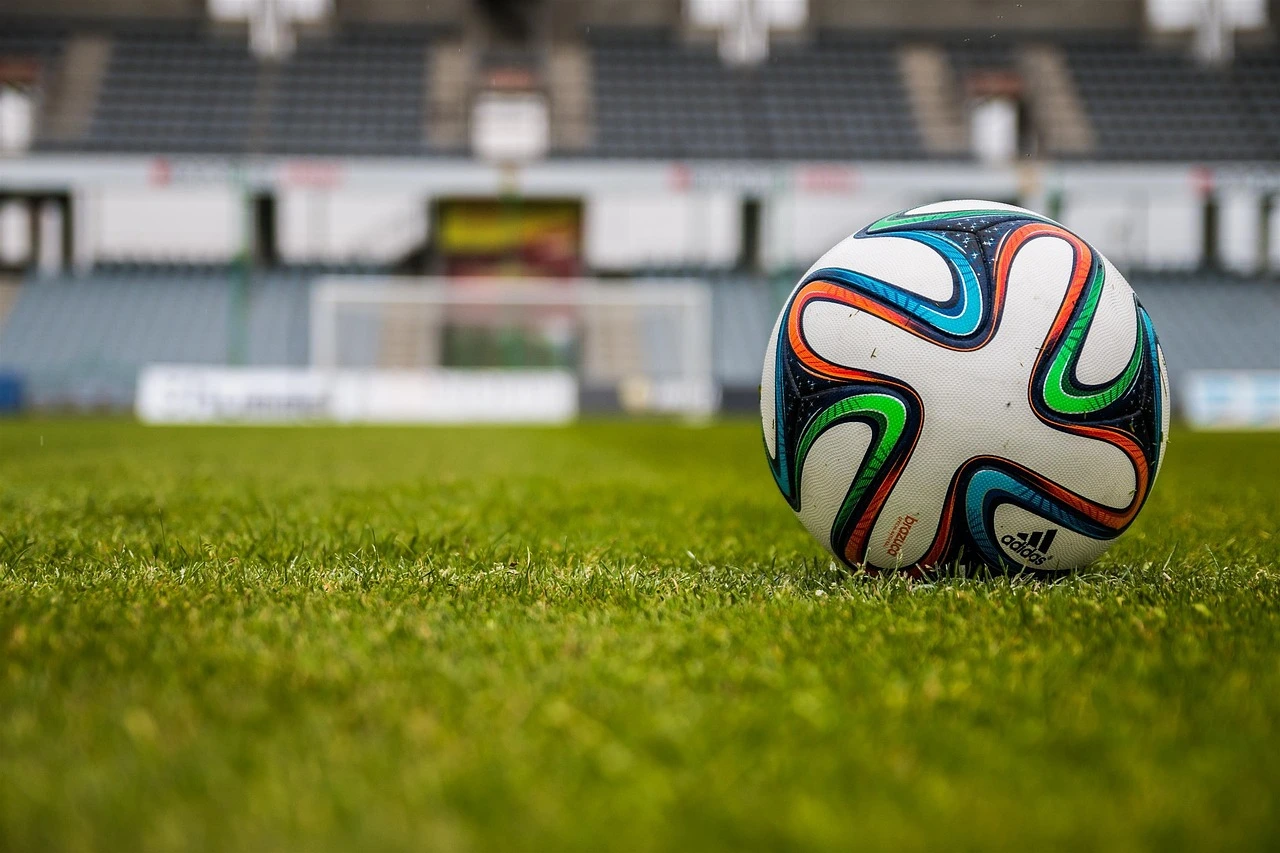 A soccer ball on grass with Horseshoe Falls and rising mist in the background.