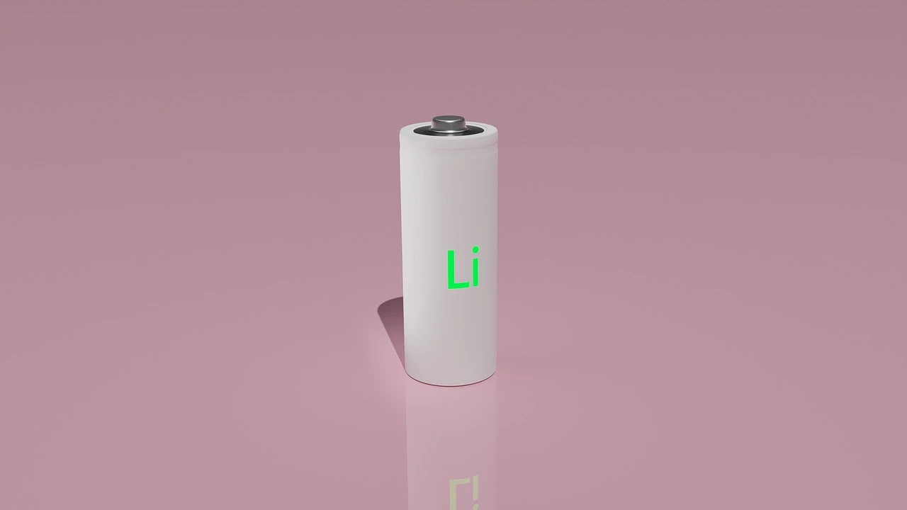 A close-up of a lithium-ion battery pack and charging cable sitting on a wooden tabletop in a residential setting.