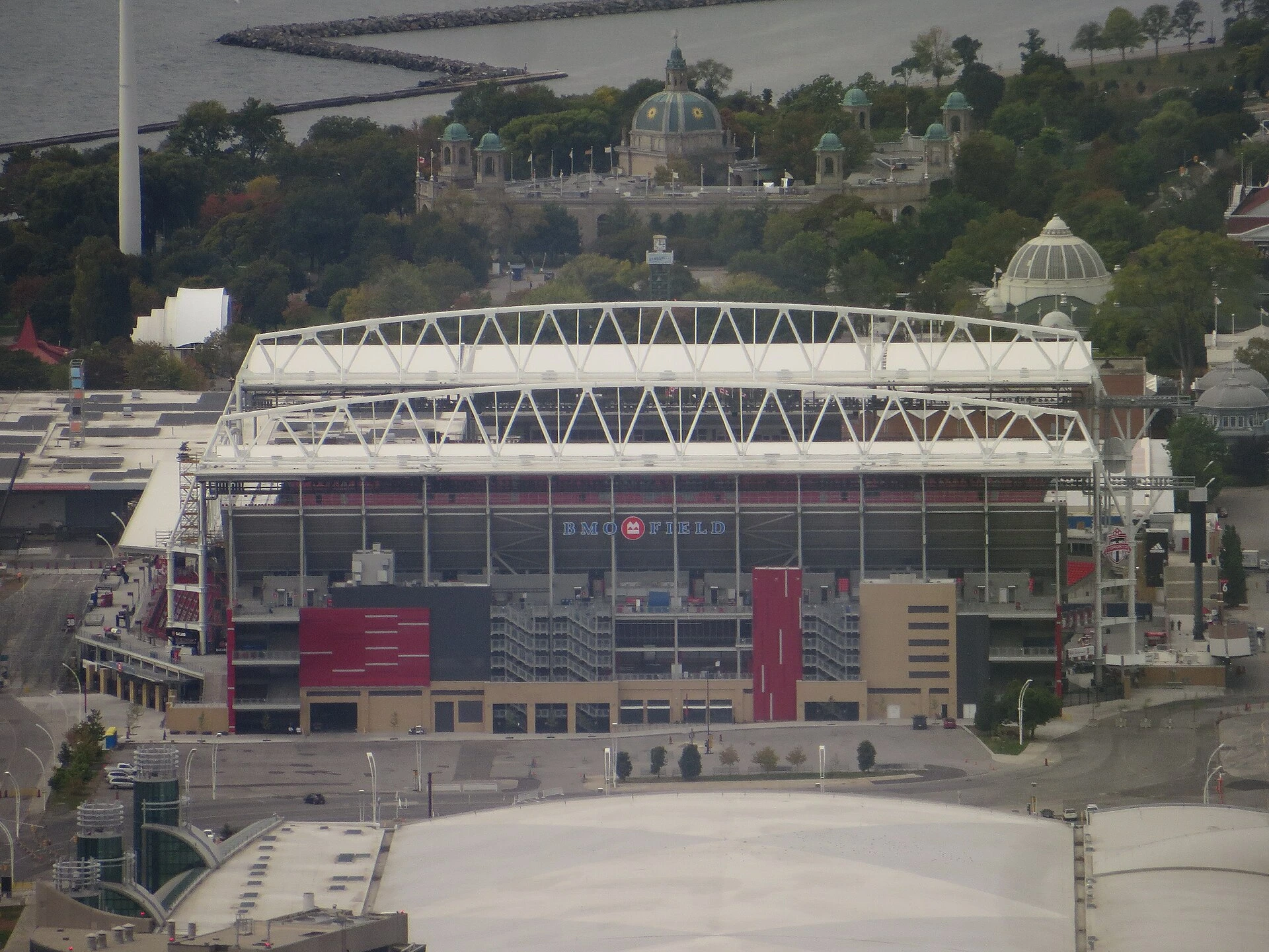 Soccer fans walking toward a Toronto stadium entrance on a summer evening.