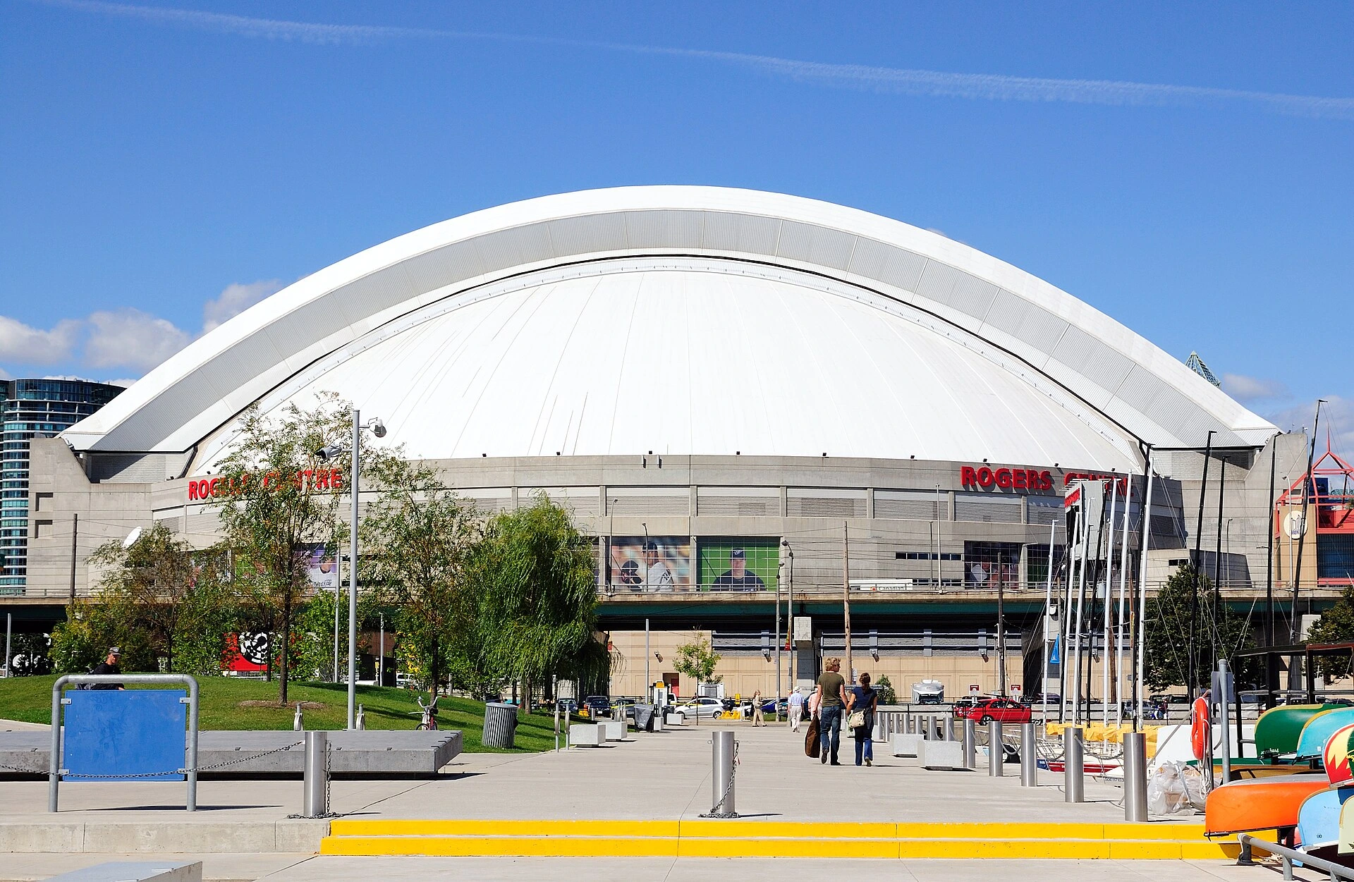 Illustration of a domed stadium and surrounding downtown buildings with distant pedestrians.