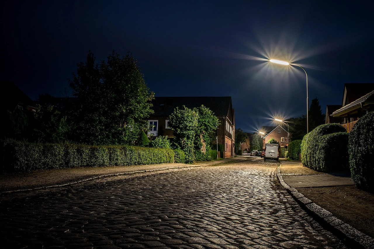 A residential street in a suburban Ontario neighborhood at dusk with streetlights along the sidewalk.