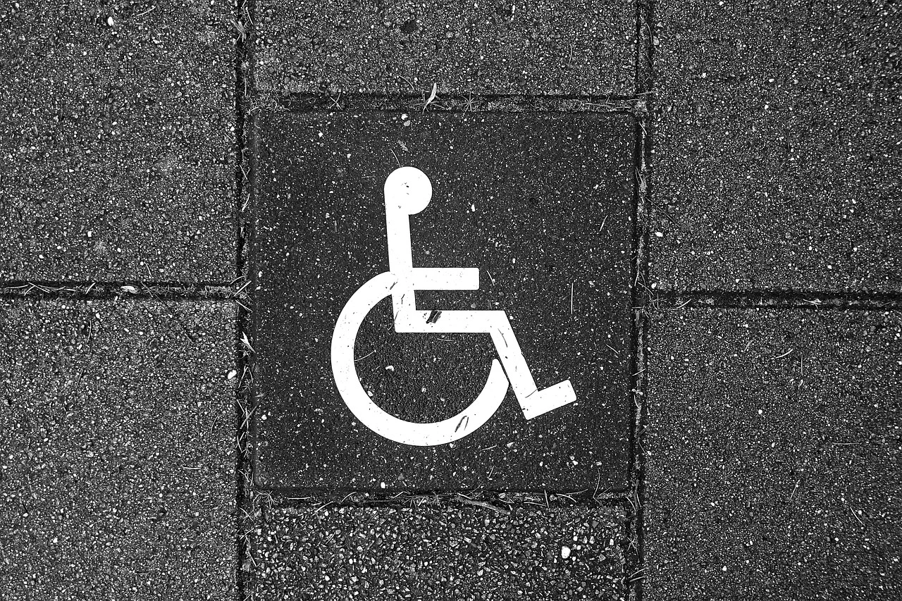 A close-up of a concrete pedestrian ramp with tactile paving on a sidewalk in Pickering during autumn.