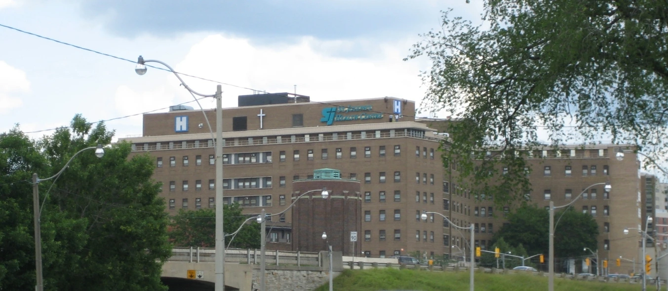 An unoccupied hospital imaging room with a CT scanner and examination table.