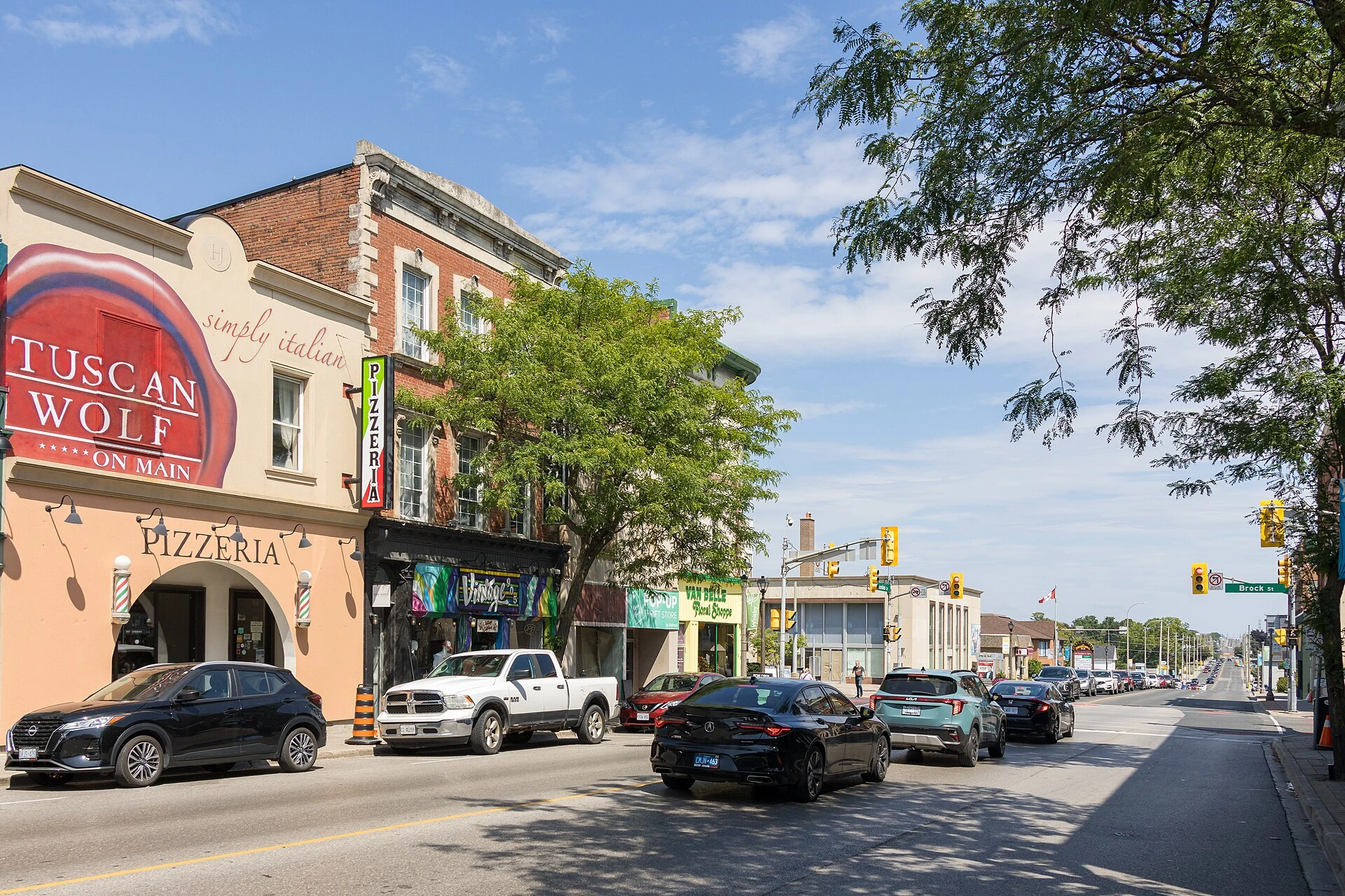 Illustration of a downtown parking lot with storefronts and trees on a spring morning.